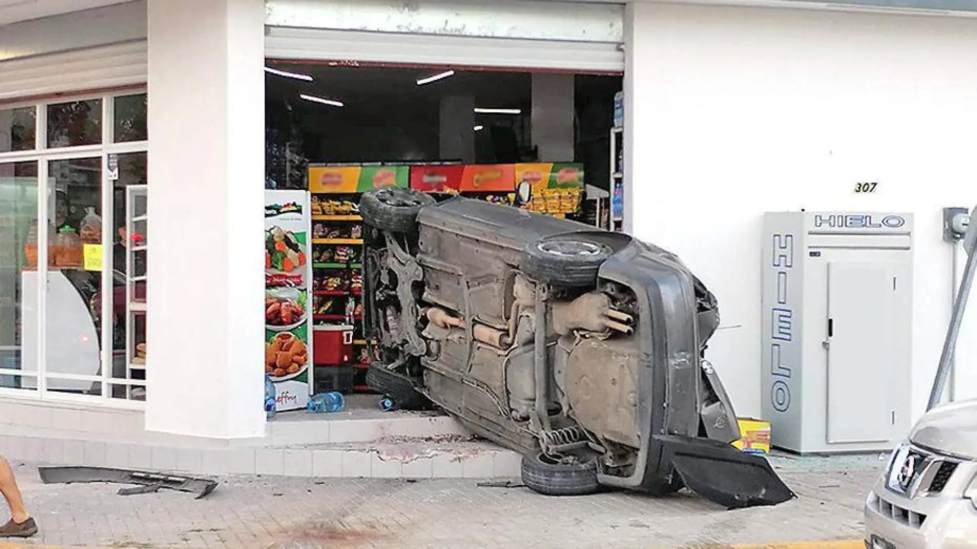 auto volcado dentro de tienda